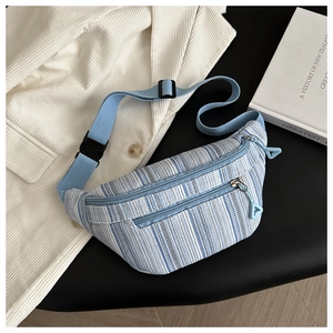 Detail of blue and white striped canvas waist bag with layered zippers and adjustable strap