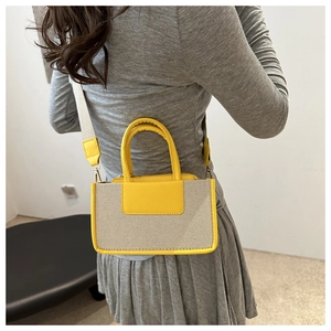 Detail of crossbody bag with yellow PU trim and wide fabric strap in casual style