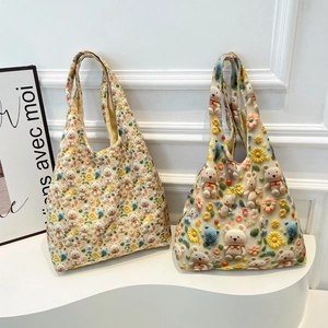Floral canvas tote bags with 3D crochet flowers and knit bears on a white display stand