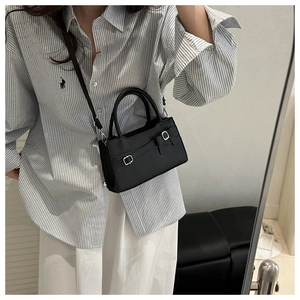 Detail view of the black minimalist crossbody square bag with silver metal buckles
