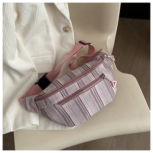 Detail of pink and purple striped belt bag with nylon strap on white corduroy