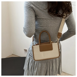 Detail of the small square crossbody bag with brown leather trim and beige canvas fabric