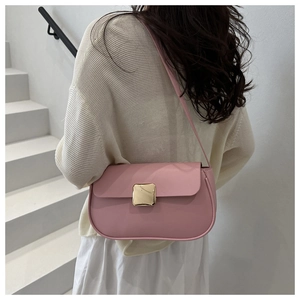 Close-up of pink leather shoulder bag featuring a gold square buckle on white stairs