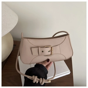Detail einer minimalistischen beigen PU-Leder-Achseltasche mit großer Goldschnalle