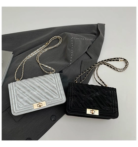 Sacs à bandoulière matelassés en argent et noir posés sur un blazer gris élégant