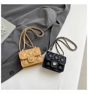 Détail de mini sacs bandoulière matelassés en noir et beige avec fermoirs fleuris