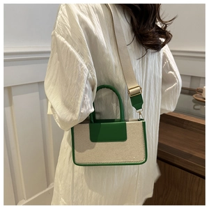 Detail of a vintage-style canvas and leather crossbody bag with green contrast trim