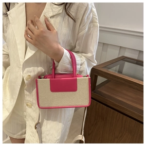 Contrast rose pink leather and canvas crossbody bag worn by a model in a minimal interior