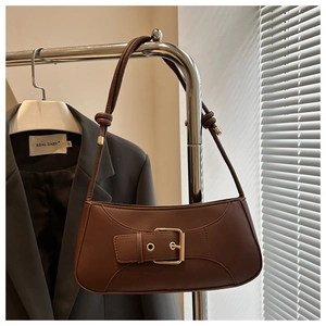Detailansicht der dunkelbraunen Leder Baguette Tasche mit goldener Schnalle und Knotendetail