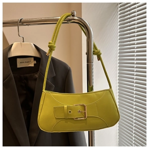Detail der neongrünen Ledertasche mit großer Gold-Schnalle und geknotetem Schultergurt