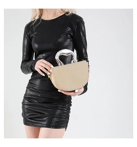Détail d'un sac demi-lune tissé beige avec une poignée métallique argentée unique