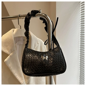 Detailed close-up of woven texture underarm bag with silver butterfly buckle