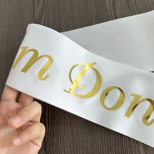 Detail of white satin graduation sash with golden foil printed I'm Done lettering