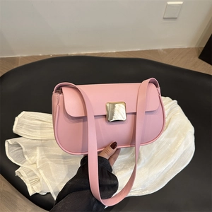 Sac à bandoulière chic en cuir rose mat avec boucle dorée et fond incurvé sur tissu blanc