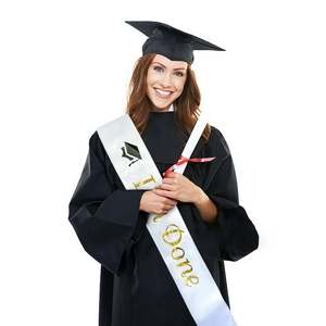 White satin graduation sash with gold I'm Done lettering worn over black academic gown