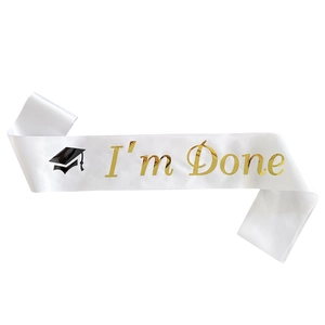 Detailed view of white satin graduation sash with golden I'm Done text and cap icon