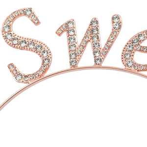 Gros plan du serre-tête d'anniversaire or rose avec strass blancs et lettrage SWEET brillant