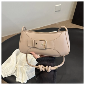 Dettaglio borsa a mezzaluna beige in pelle con fibbia metallica e tracolla con nodo