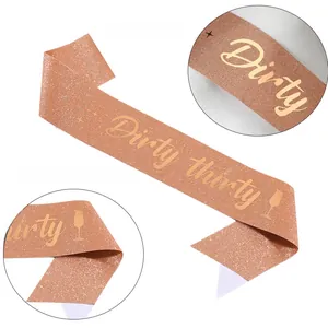 Detail of rose gold Dirty Thirty birthday sash with golden glitter finish and starry icons