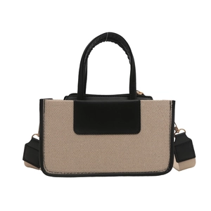 Modern beige canvas tote bag with black leather accents and a striped woven strap