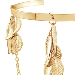 Golden leaf arm cuff with delicate leaf pendants and fine metal chains in a minimalist style