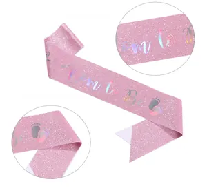 Detail of pink satin Mom to Be sash with iridescent laser lettering for baby showers