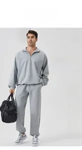 Detail view of men's grey half-zip sports sweatshirt and joggers for training