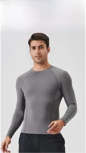 Detailed view of gray compression top featuring breathable mesh panels and raglan sleeves