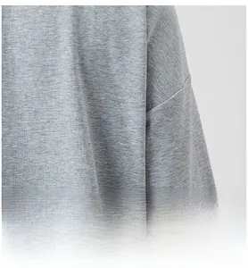 Detail view of men's grey tracksuit featuring drop shoulder design and textured fabric