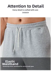Detail of light gray sports trousers showing elastic waistband and metal-tipped drawstring
