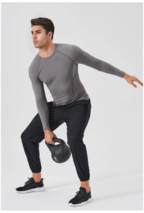 Detail of grey compression top and black joggers worn during 8kg dumbbell workout
