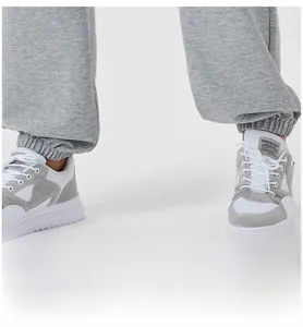 Close-up of men's grey joggers featuring elasticated cuffs and matching sneakers