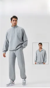 Detailed view of men's grey tracksuit featuring half-zip fleece sweatshirt and joggers