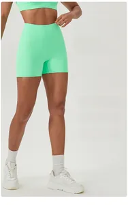 Detailed close-up showing high-waisted mint green fitness shorts with tummy control compression