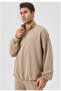 Detailed view of khaki men's sports sweatshirt with half-zip collar and ribbed cuffs