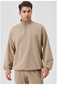 Detail of khaki half-zip men's sweatshirt showing fine knit texture and ribbed cuffs