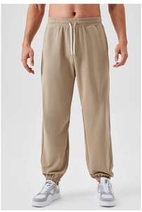 Detail view of khaki joggers with elastic drawstring waistband and ribbed knit cuffs