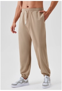 Detail view of men's khaki waffle jogger pants with elastic waistband and contrast drawstrings