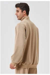 Detail view of khaki half-zip men's sweatshirt fabric texture and ribbed cuff design