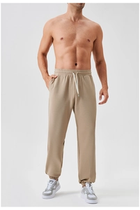Detail of khaki men's joggers showing elastic drawstring waistband and tapered ankle cuffs