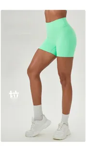 Detail of high waist mint green fitness shorts showing peach lift and elastic shaping effect