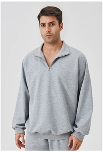 Detail of light grey half-zip sweatshirt showing ribbed cuffs and textured knit fabric