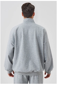 Rear view of men's loose fit grey tracksuit showing high weight knit fabric texture