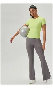 Détail du t-shirt de yoga vert citron et legging évasé gris avec ballon de yoga
