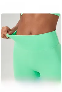 Close-up showing the high elasticity and tummy control design of green yoga shorts