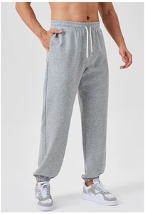 Detail of men's grey jogger pants showing elastic waistband and adjustable white drawstring