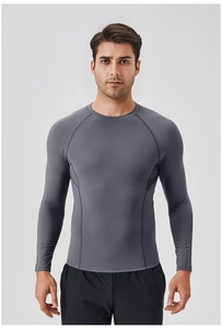 Detailed view of grey compression shirt showing reinforced flatlock seams and athletic fabric