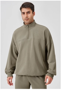 Detail of men's quarter-zip sports sweatshirt with ribbed cuffs and sage green fabric