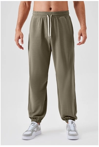 Detail of olive green joggers featuring adjustable drawstring waist and ribbed ankle cuffs