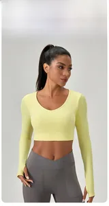 Détail du haut court de yoga jaune clair ajusté avec col en V et passe-pouces